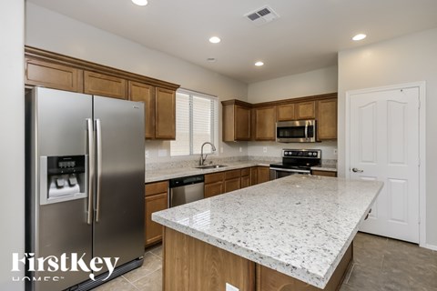 A kitchen with a granite countertop and a refrigerator.