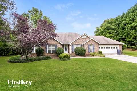 a home with a lawn and a tree in front of it