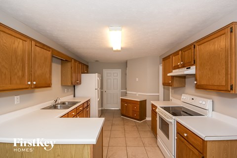 a kitchen with white counters and wooden cabinets and white appliances