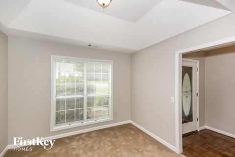 a living room with a large window and a door to a hallway