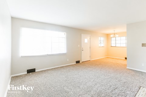 a living room with carpet and a window and a door