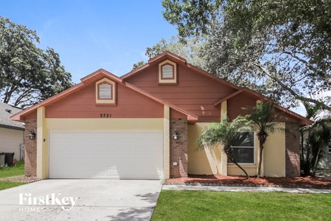 a house with a white garage door and a palm tree