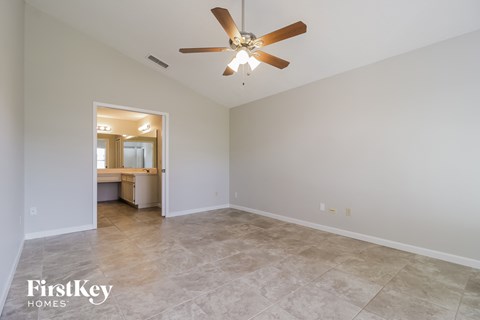the spacious living room with tile flooring and a ceiling fan