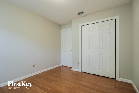 a bedroom with two closets and a wood floor