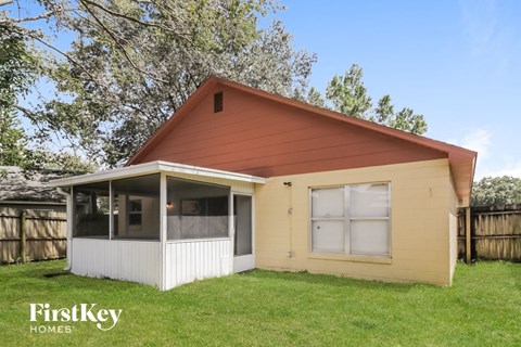the front of a small yellow house with a red roof