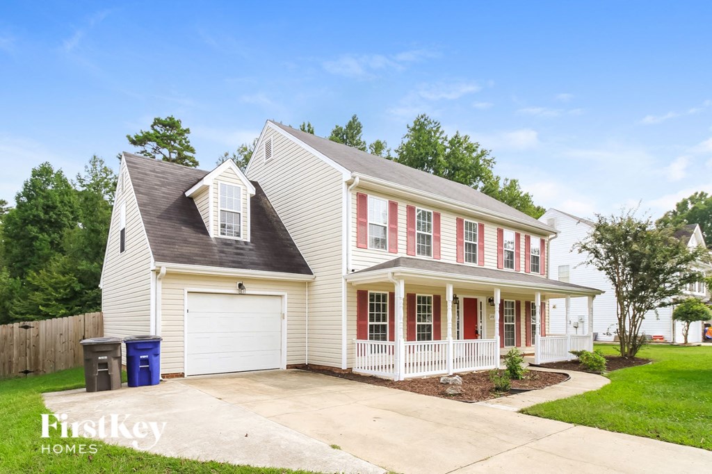 A two-story house with a garage and a driveway.