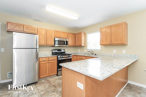 A kitchen with wooden cabinets and a granite countertop.