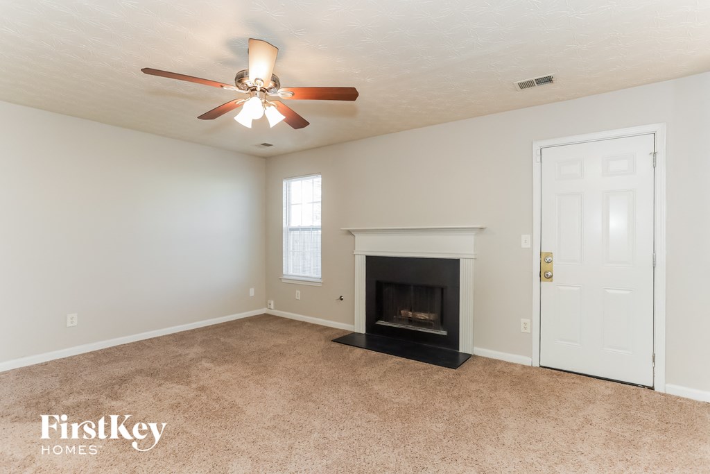 a living room with a fireplace and a ceiling fan