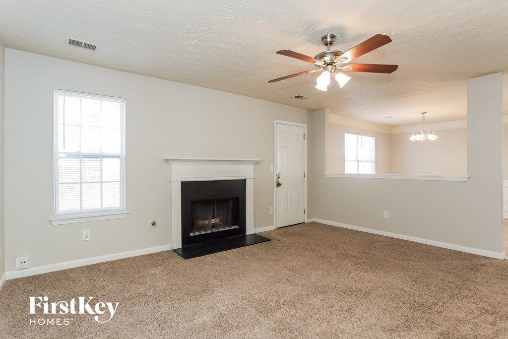 a living room with a fireplace and a ceiling fan