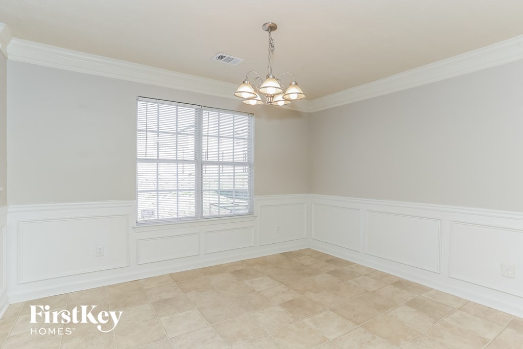 a dining room with white walls and a window