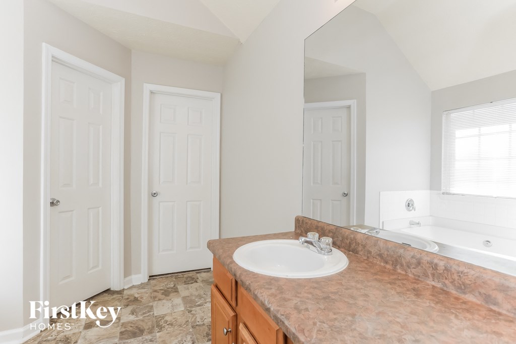 a bathroom with a sink and a mirror and a bath tub