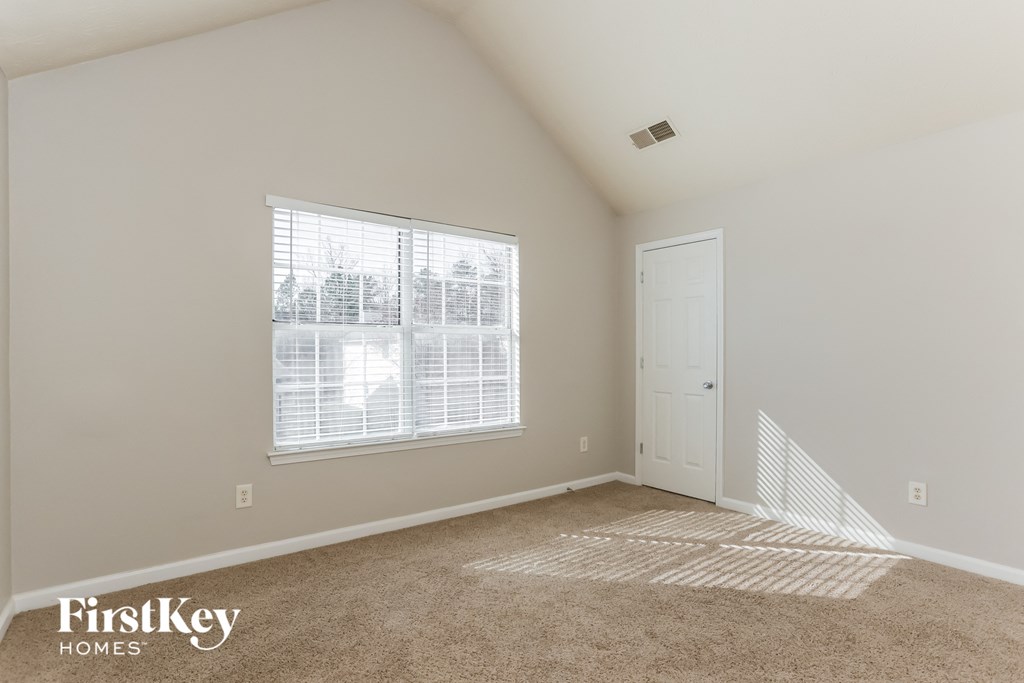 a bedroom with a large window and a white door