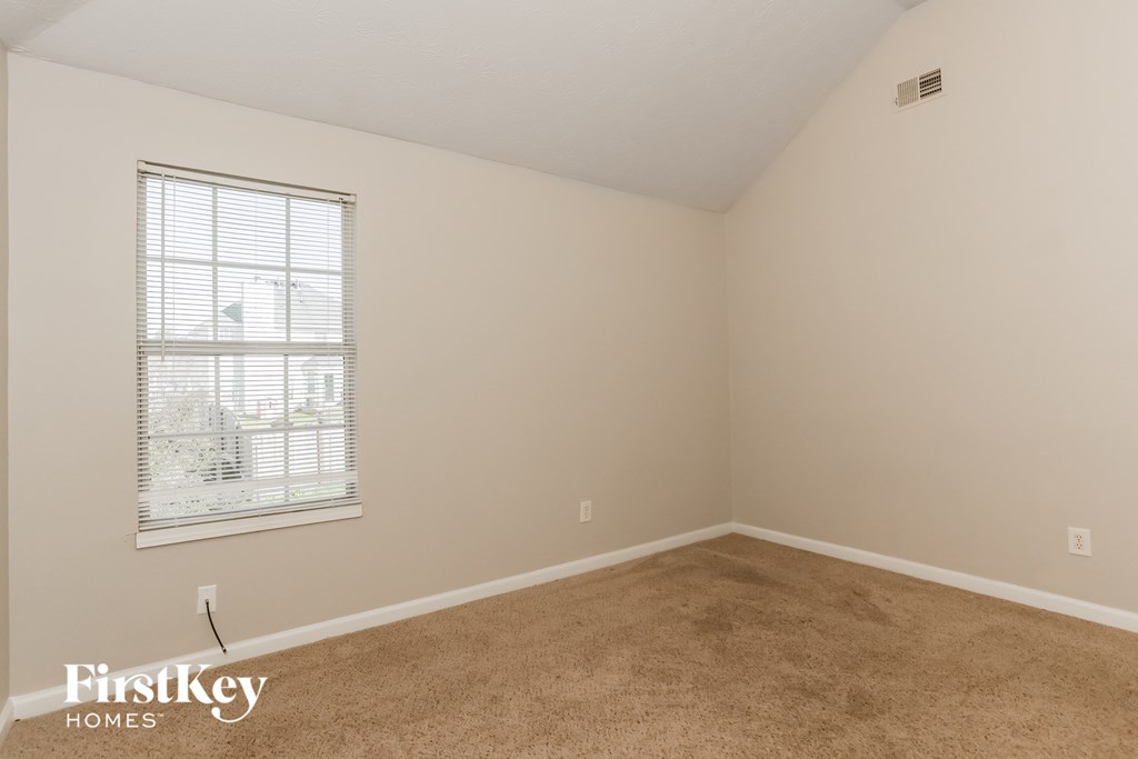 a bedroom with a carpeted floor and a window