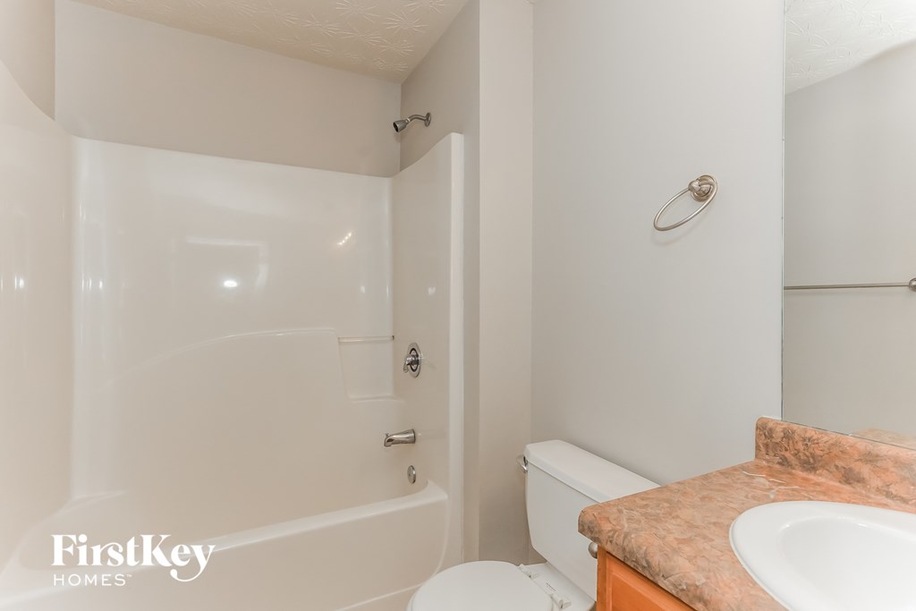 a bathroom with a toilet and a tub and a sink