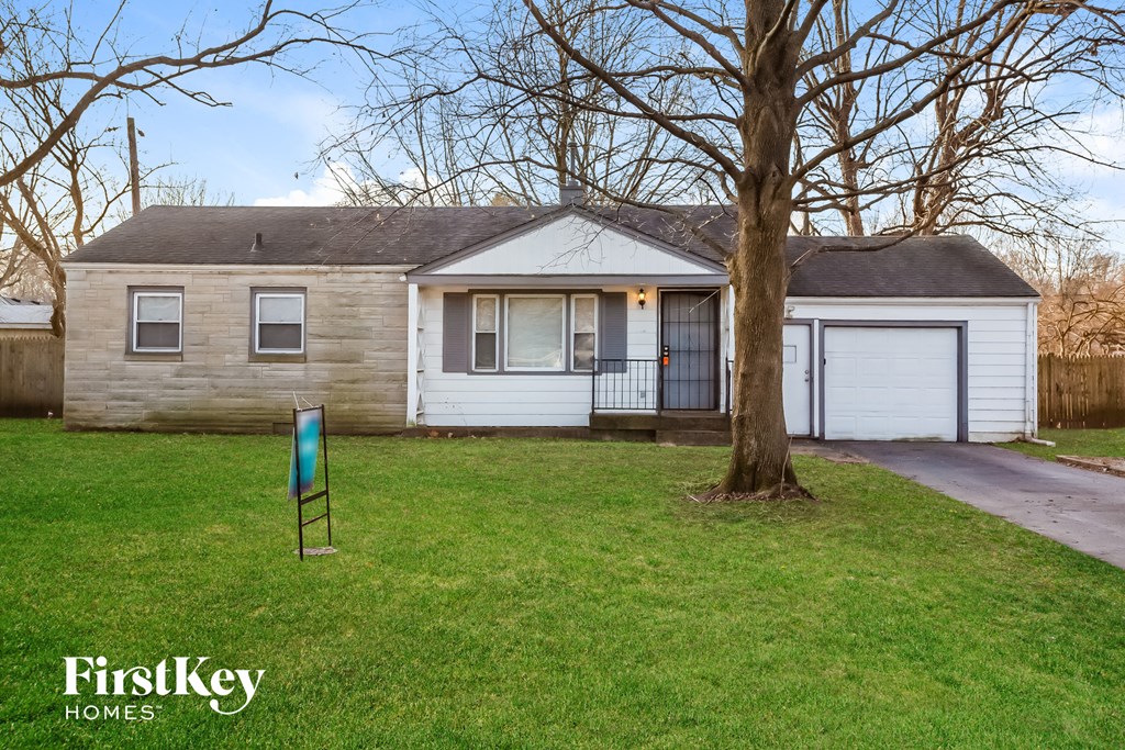 a house with a yard and a tree in front of it