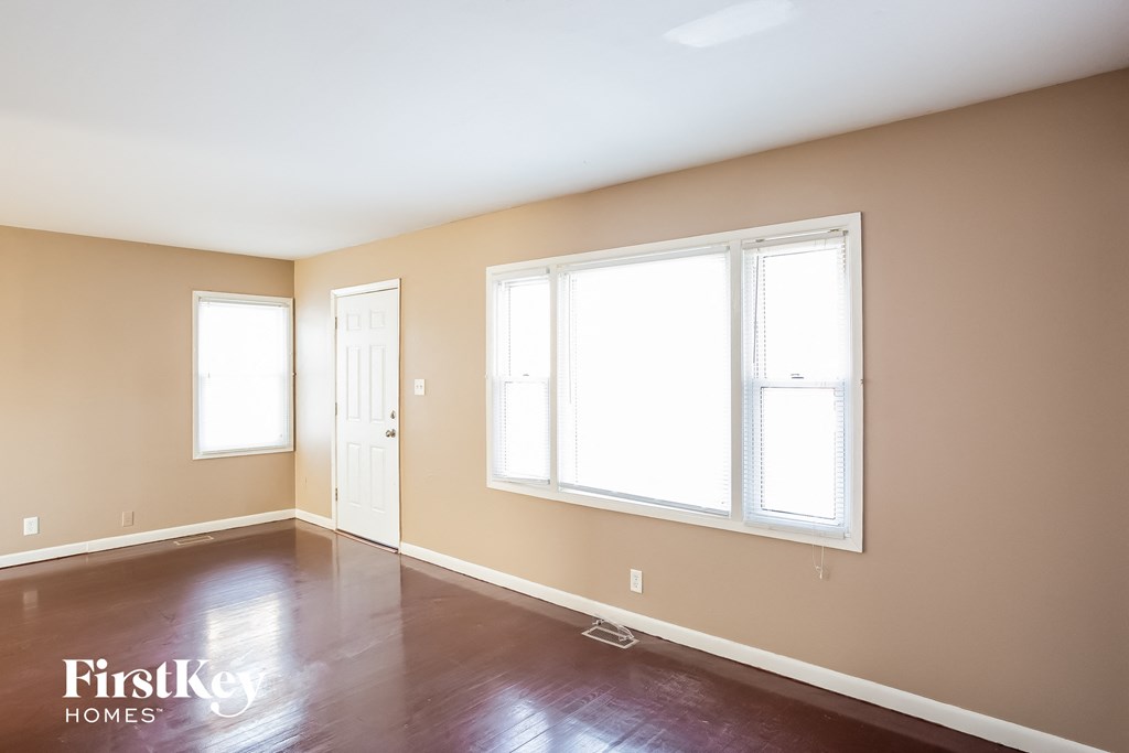 a living room with wood floors and large windows