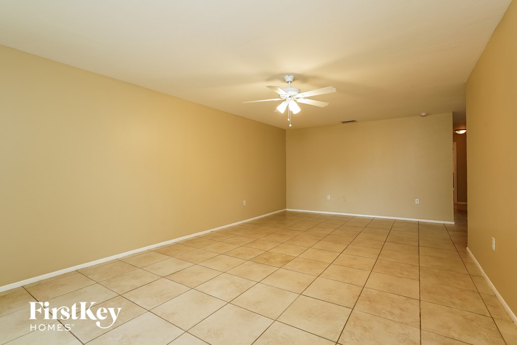 a empty room with a ceiling fan and a tiled floor
