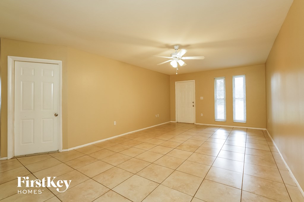 a large living room with a tile floor and a ceiling fan