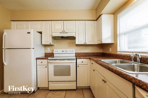 a kitchen with white appliances and white cabinets and granite counter tops
