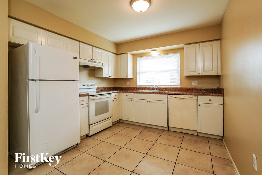 full view of the kitchen with white cabinets and appliances