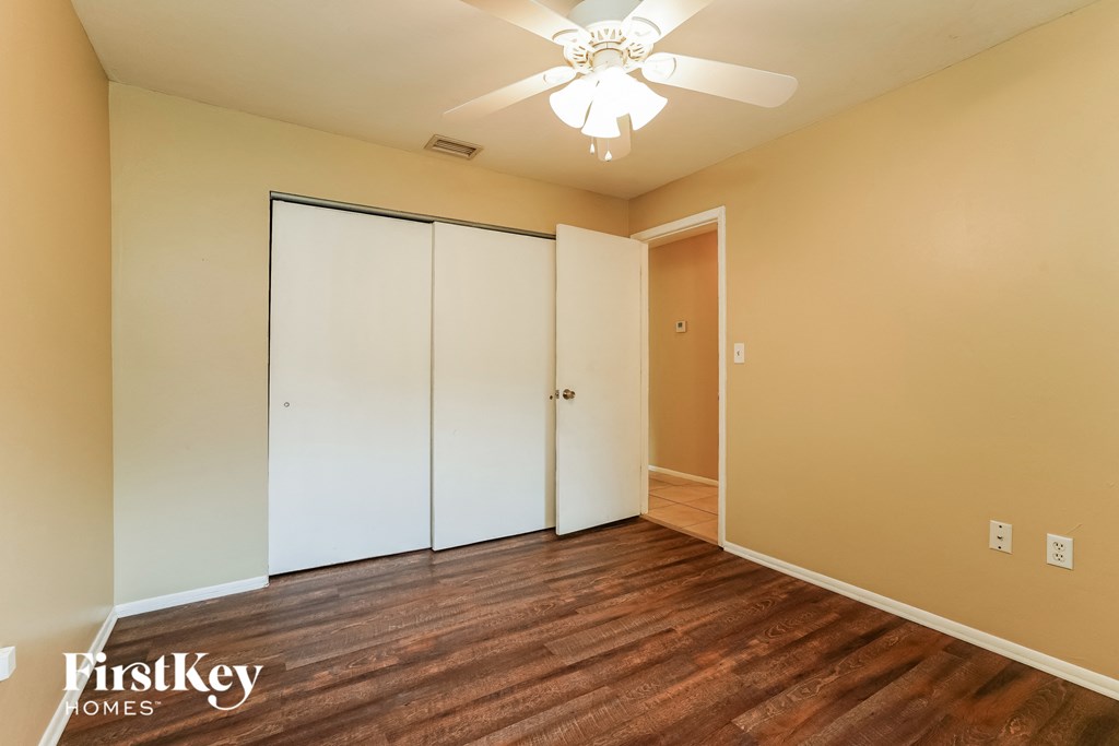 a bedroom with a closet and a ceiling fan