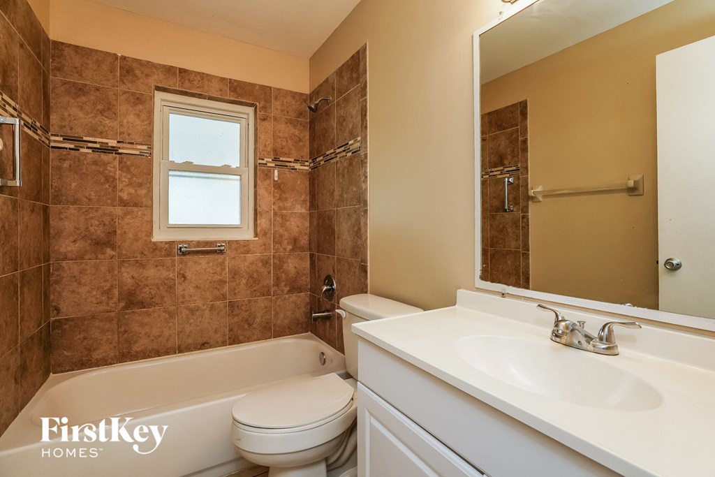 a bathroom with a sink toilet and tub and a mirror