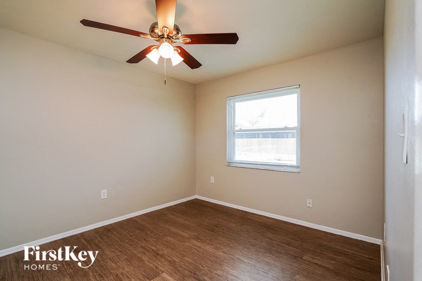 a bedroom with a ceiling fan and a window