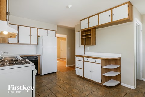 a kitchen with white cabinets and a stove and a white refrigerator