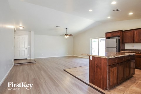 A kitchen with wooden cabinets and a marble countertop.