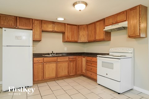A kitchen with wooden cabinets and a white fridge.