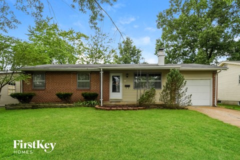 a brick house with a lawn and a white garage door