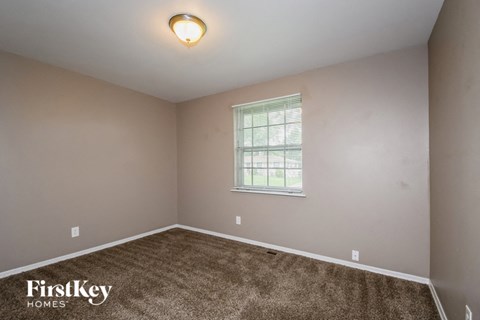 a bedroom with a carpeted floor and a window