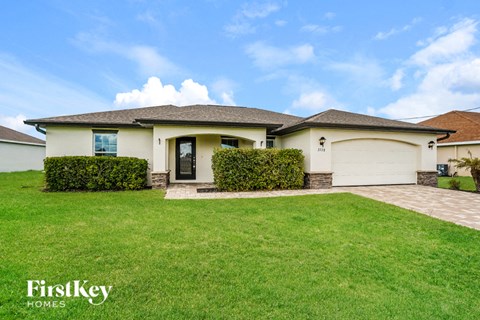 A house with a well-maintained lawn and a clear sky above.