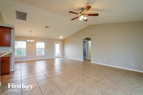 A spacious room with a ceiling fan and tiled flooring.