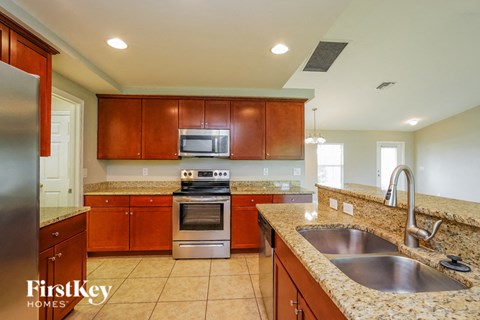 A kitchen with brown cabinets and a stainless steel refrigerator.