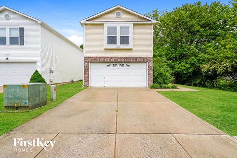 A two-story house with a garage is for sale.