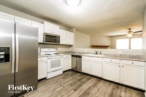 A kitchen with white cabinets and a stainless steel refrigerator.