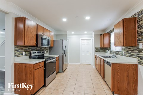 A kitchen with wooden cabinets and a tiled floor.
