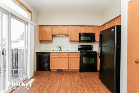 A kitchen with wooden cabinets and black appliances.