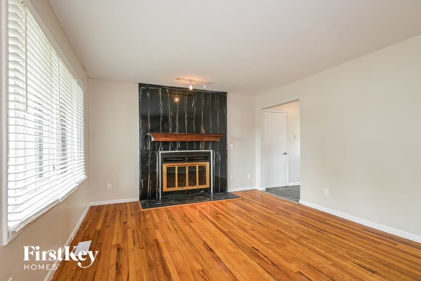 A room with a fireplace and wooden floors.