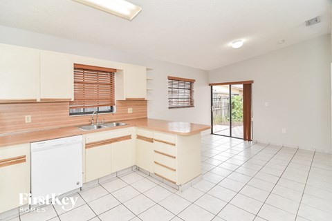 A kitchen with white cabinets and a white dishwasher.