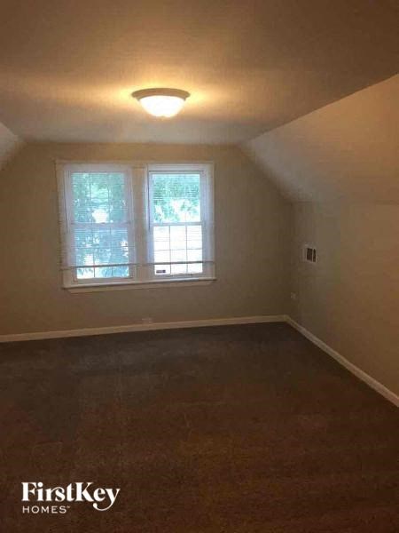 A room with a window and a light on the ceiling.