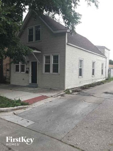 A house with a grey siding and a red stripe on the sidewalk.