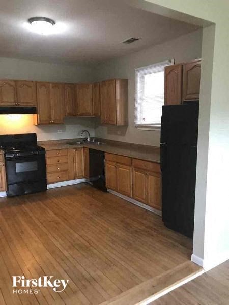 A kitchen with wooden cabinets and black appliances.