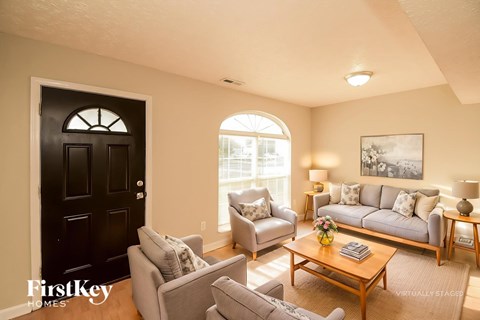 A black door is on the left of a living room.