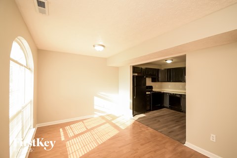 A sunny room with a kitchen in the background.