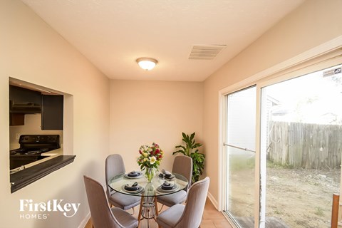 A dining room with a glass table and chairs.