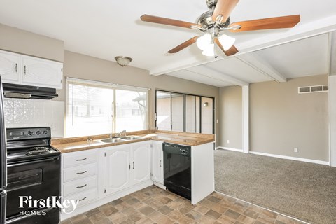 A kitchen with a black stove top oven and a black dishwasher.