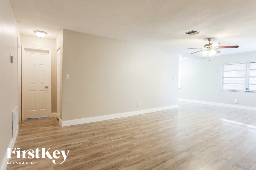 A room with wooden flooring and a ceiling fan.