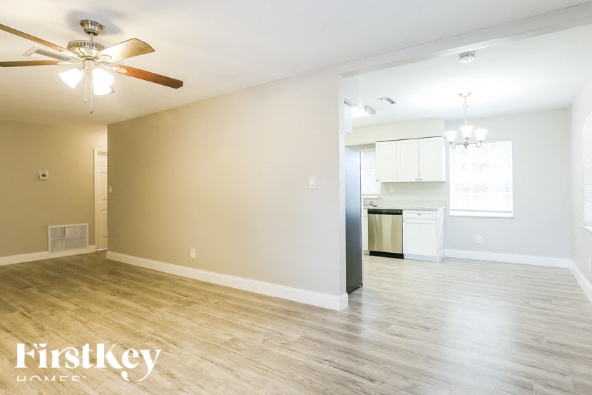 A spacious room with a ceiling fan and lighting fixtures.